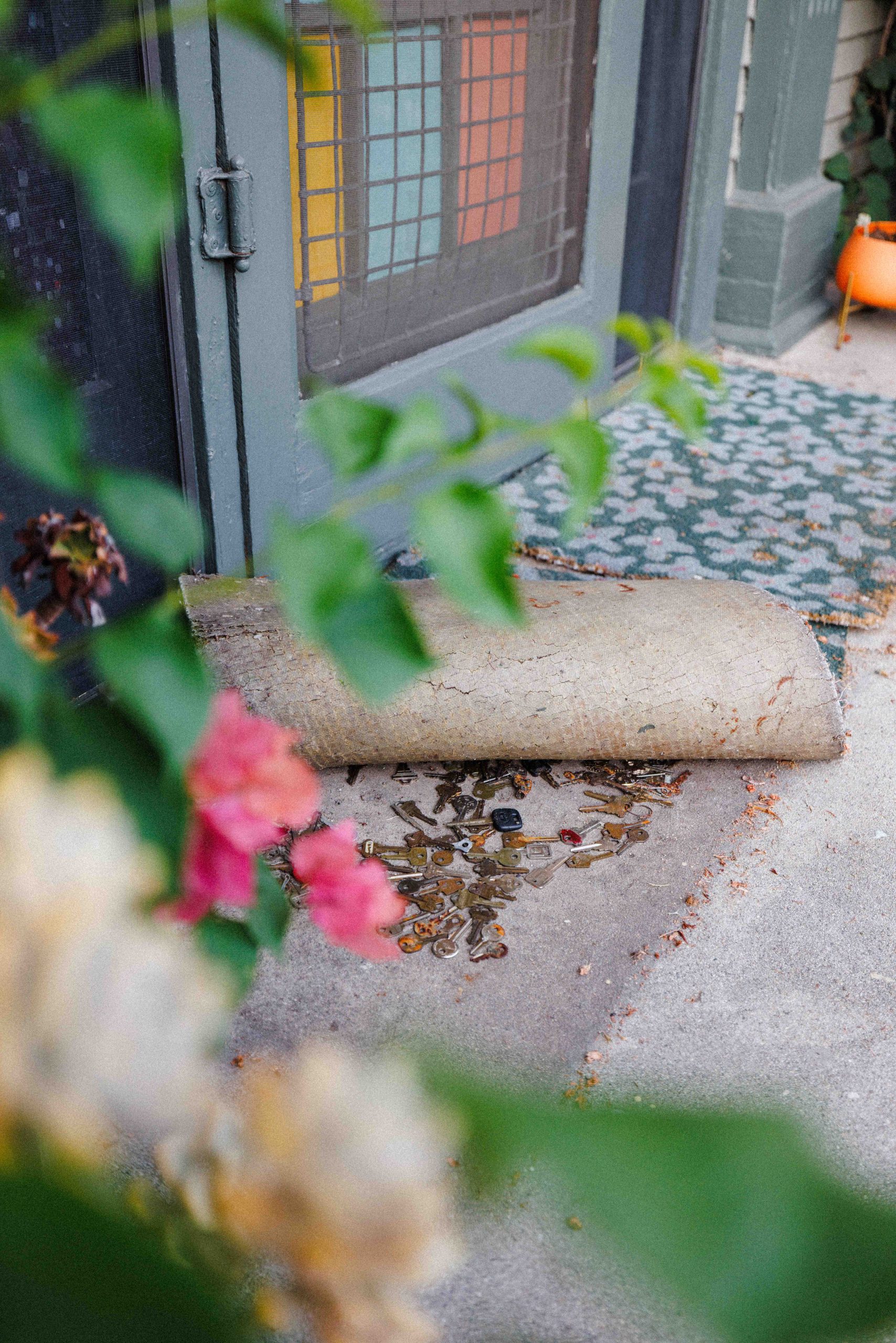 A lifted doormat reveals dozens of keys at the Museum entrance.