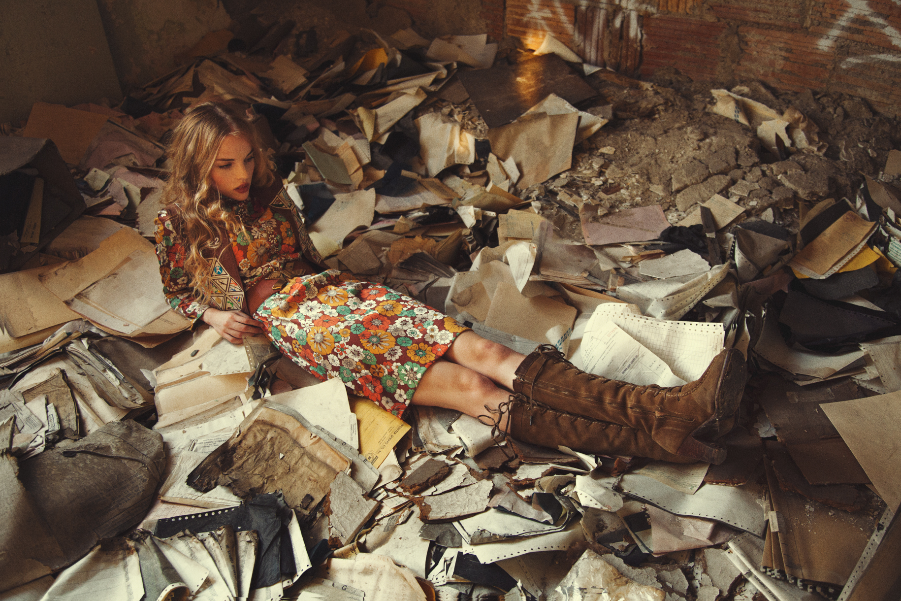 Ruby June lies among scattered papers and debris in a dim room in Detroit.