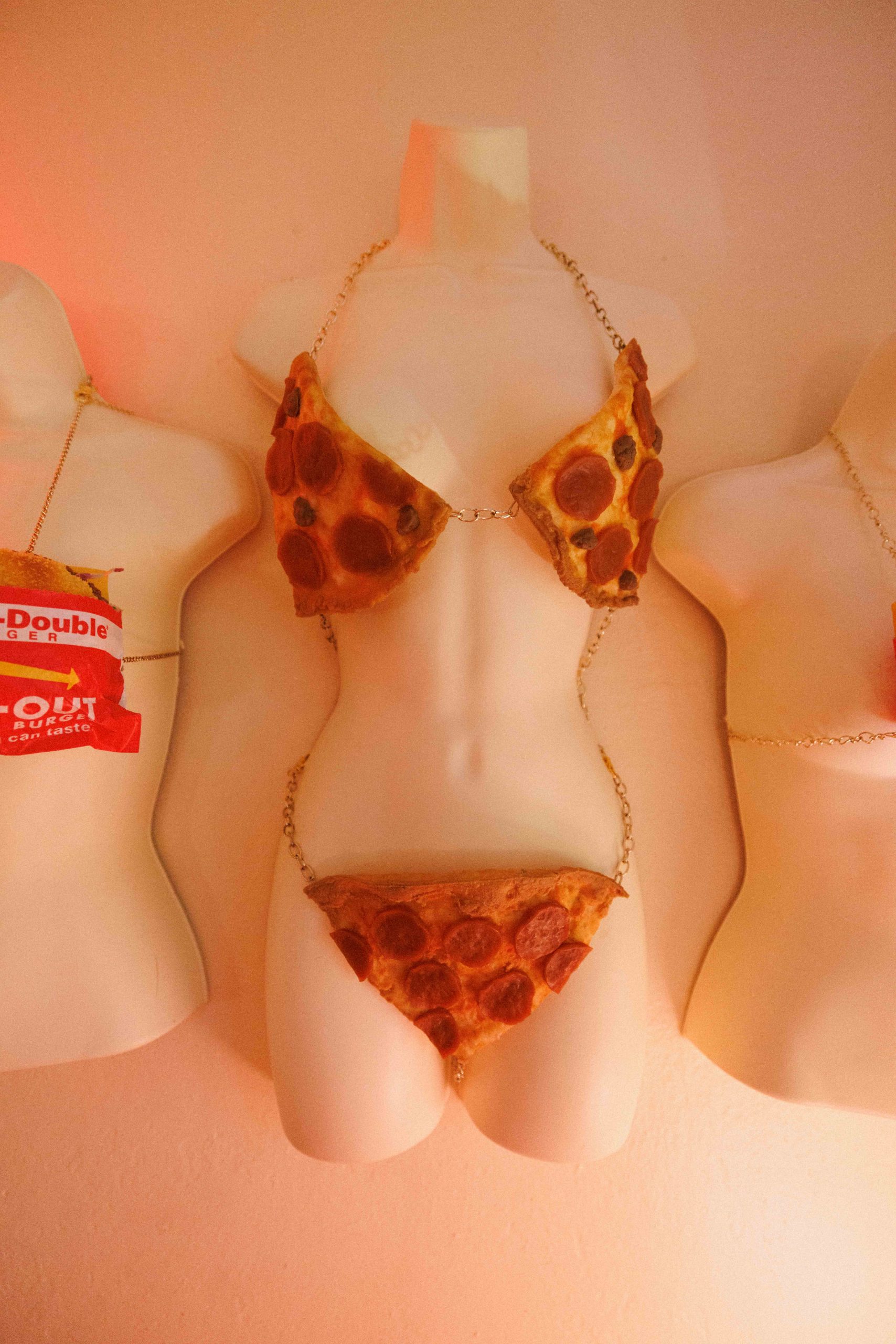 A torso mannequin wears a bikini made from replica pizza slices.