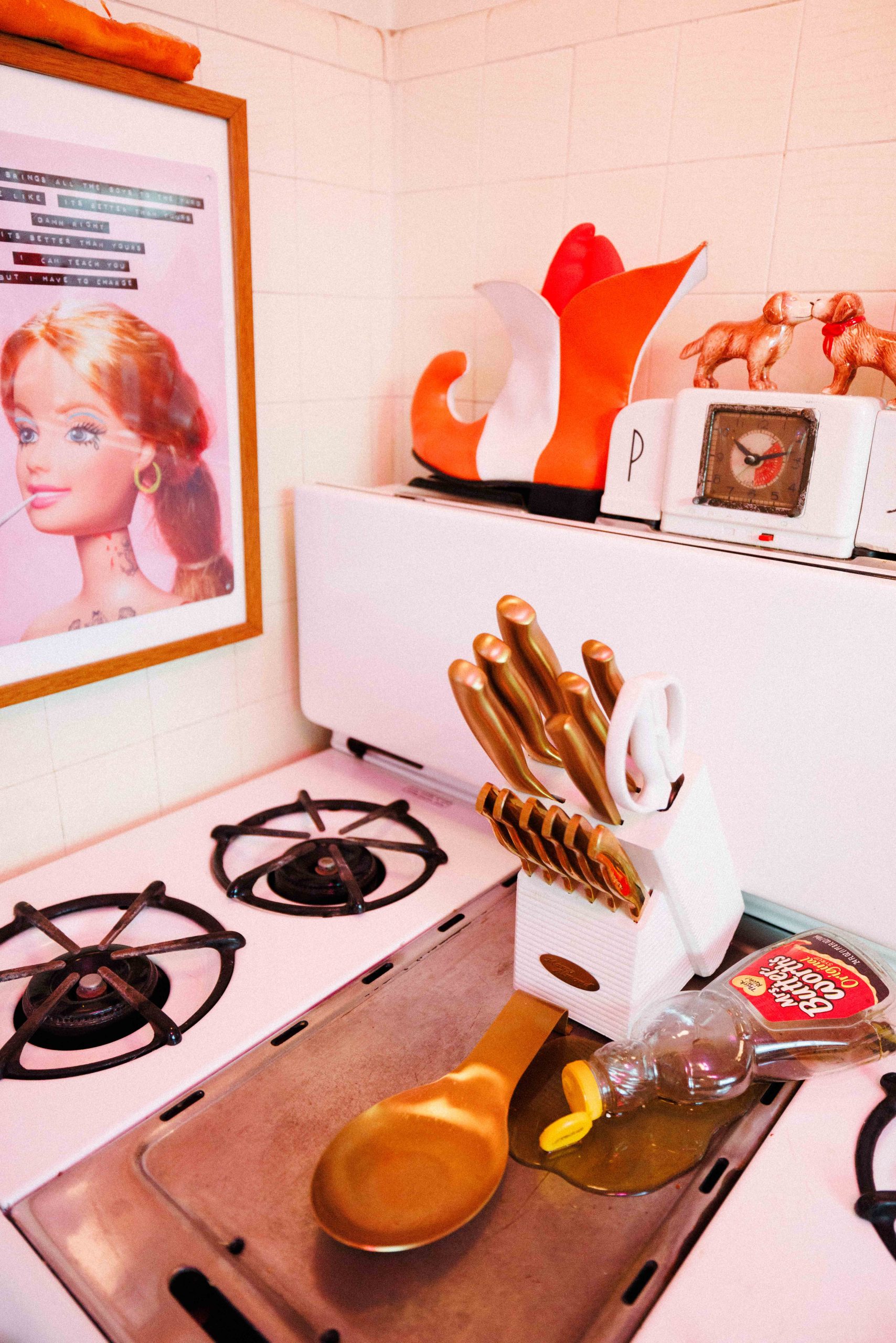 A kitchen counter with hand-shaped utensil holders, a toaster, and a framed portrait.
